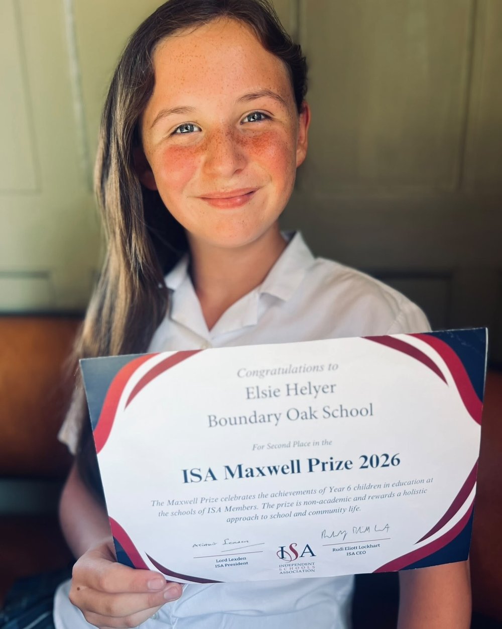 Elsie smiling and holding her certificate for second place in the ISA Maxwell Prize 2026