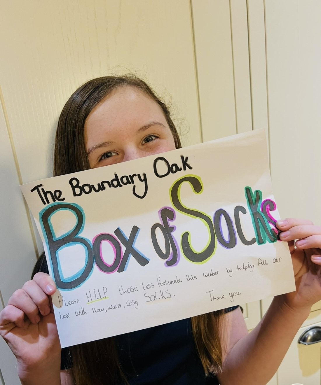 Elsie holding a handmade poster reading The Boundary Oak Box of Socks